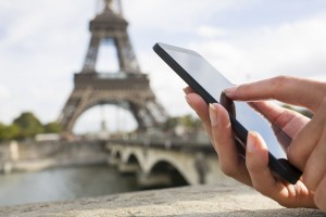 Woman in Paris using her cell phone in front of Eiffel Tower