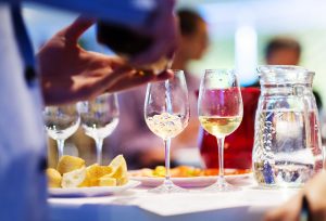 Unrecognizable young man pouring wine into a glass